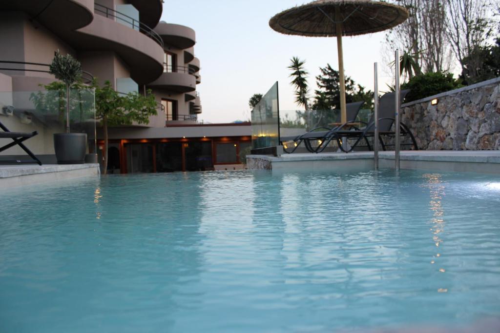 uma piscina com um guarda-sol num hotel em John Mary em Faliraki