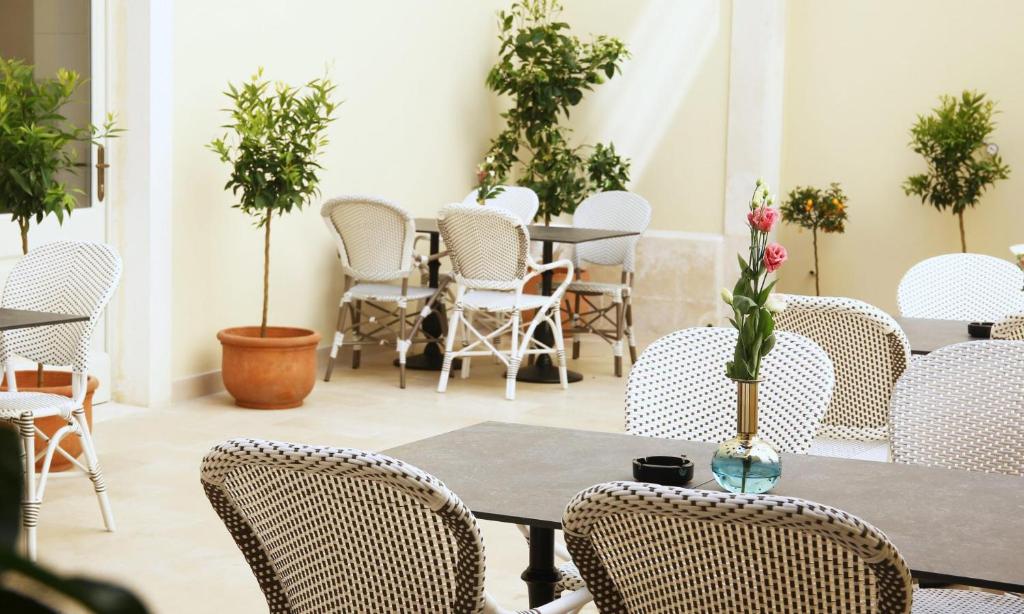 a room with tables and chairs and potted plants at Heritage hotel Santa Lucia in Split