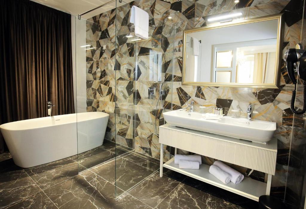 a bathroom with a tub and a sink and a mirror at Heritage hotel Santa Lucia in Split