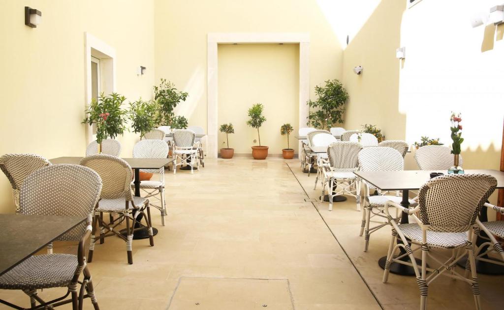 a room with tables and chairs and potted plants at Heritage hotel Santa Lucia in Split