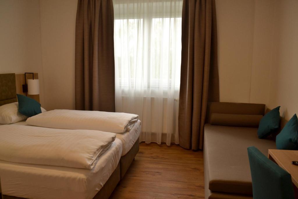 a hotel room with two beds and a window at Gasthof Kranerwirt in Lannach