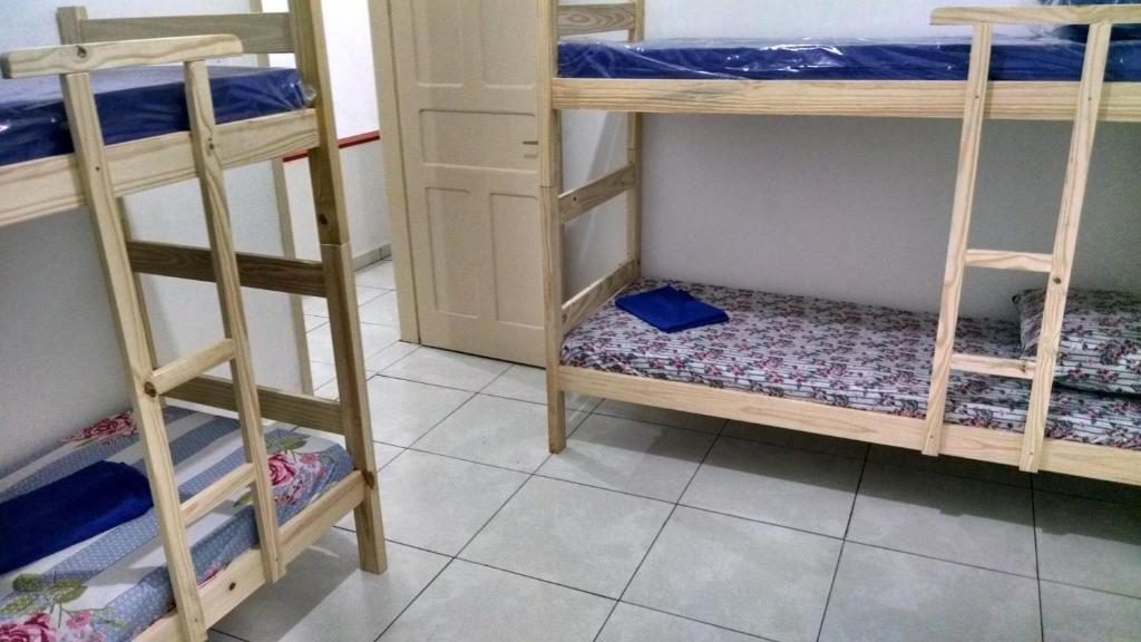 a room with three bunk beds in a room at Pousada Casa 6 in São Vicente