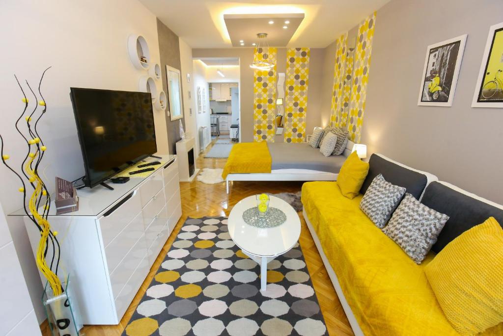 - un salon avec un canapé jaune et une télévision dans l'établissement Welcome Center, à Subotica