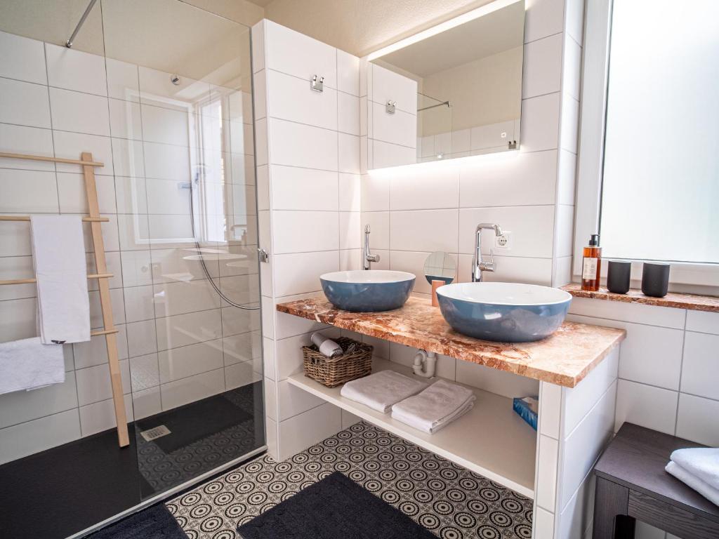 a bathroom with two blue sinks and a shower at Apartments im LOIDLs GUESTHOUSE in Traunkirchen