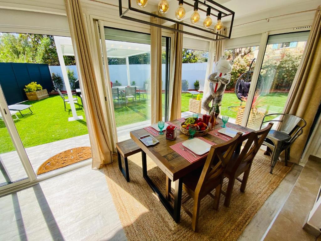 - une salle à manger avec une table, des chaises et des fenêtres dans l'établissement High Standing! 200m2 Private Garden Jacuzzi Sun Bed & Interior Spa, à Antibes