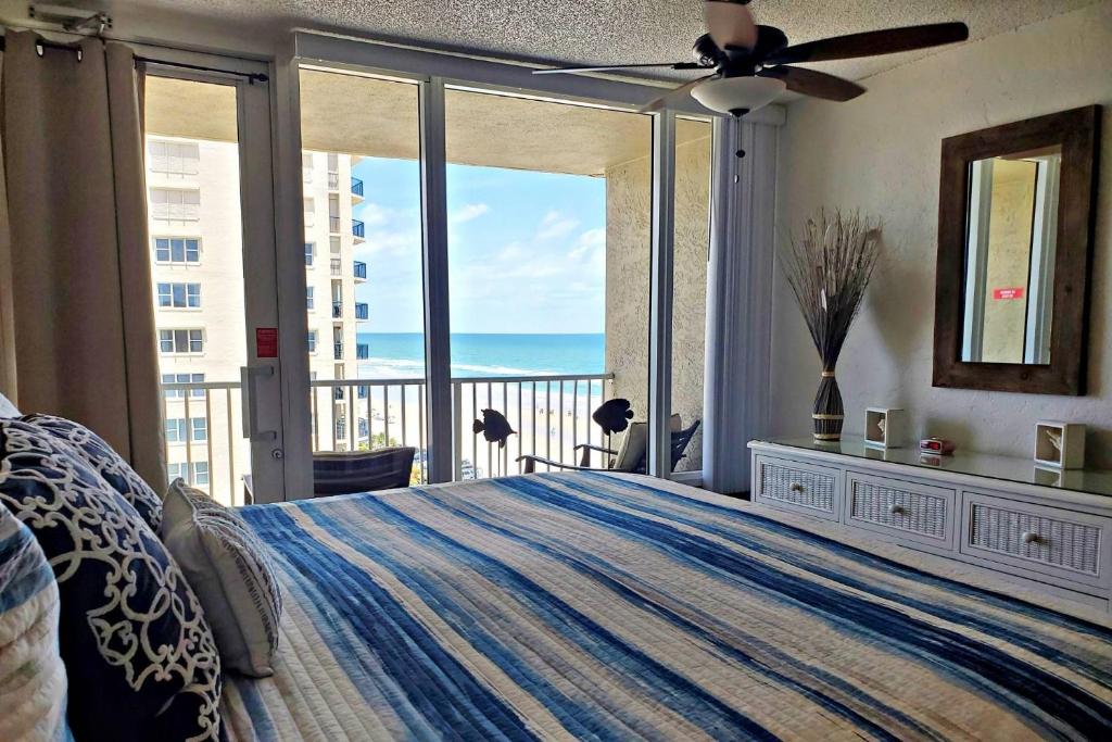 1 dormitorio con 1 cama y vistas al océano en Pirates Cove Condo Unit #704 en Daytona Beach Shores