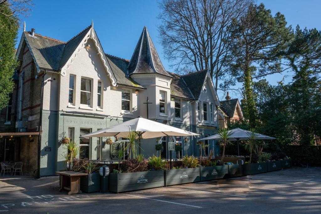 um edifício com mesas e guarda-chuvas à sua frente em The Pavilion Arms em Bournemouth