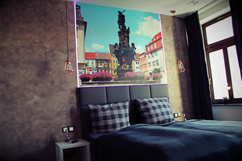 1 dormitorio con 1 cama con una foto de la ciudad en FAMILY APARTMENTS - SALZHAUSBLICK FERIENWOHNUNGEN - TOP INNENSTADT LAGE am SALZHAUS STADTZENTRUM mit HOTELBETTEN, en Zittau