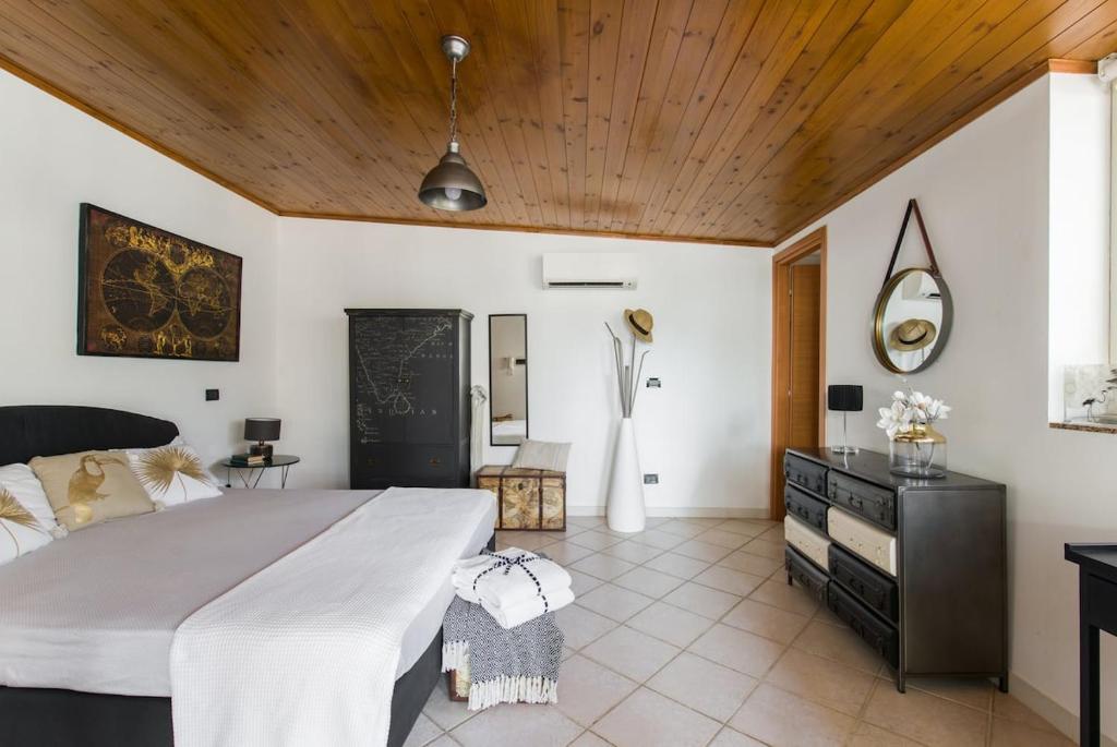 - une chambre avec un grand lit et un plafond en bois dans l'établissement La Casa del Viaggiatore, à Milazzo