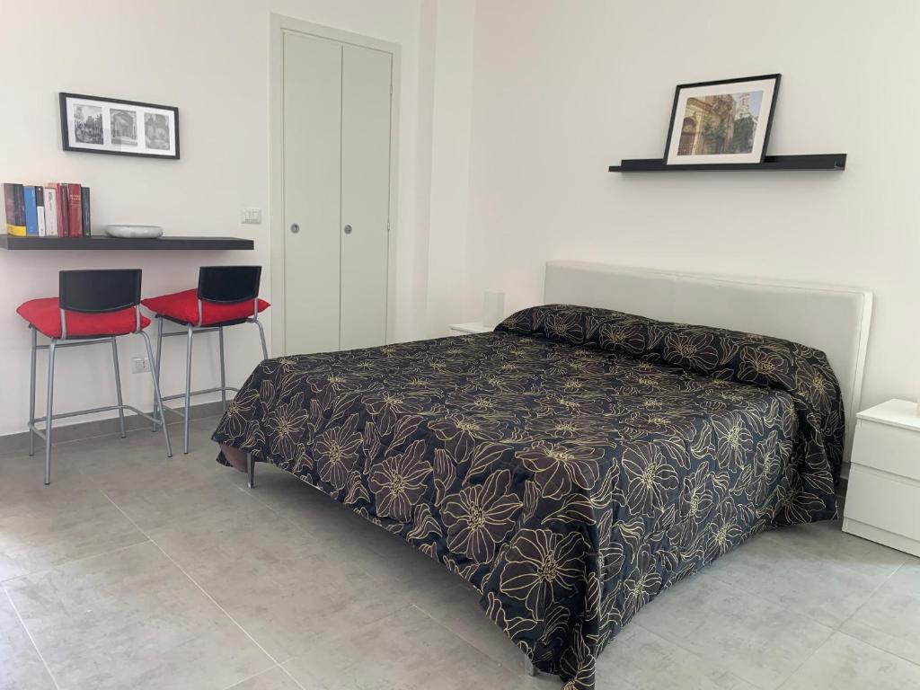 um quarto com uma cama e 2 cadeiras vermelhas em Chiara’s House em Galatina