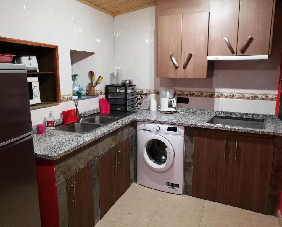 cocina con lavadora y fregadero en O Chaleciño, en Samos
