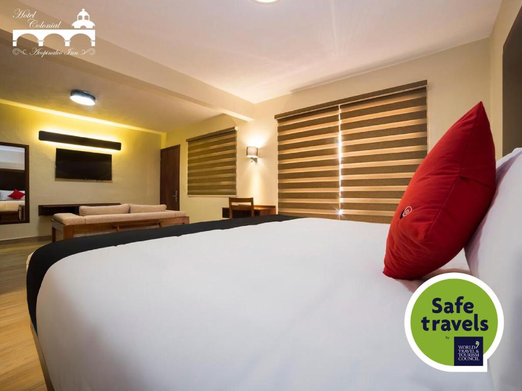 - une chambre avec un grand lit blanc et des oreillers rouges dans l'établissement Hotel Colonial Acopinalco Inn, à Acopinalco