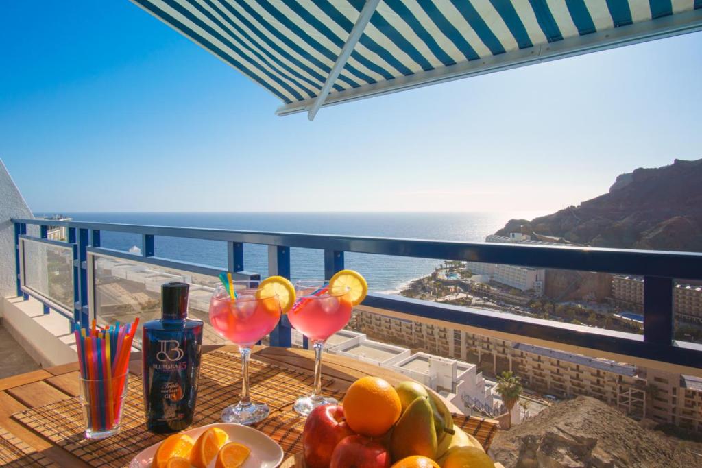 una mesa con bebidas en un balcón con vistas al océano en Stunning Views Guaranteed, en Taurito