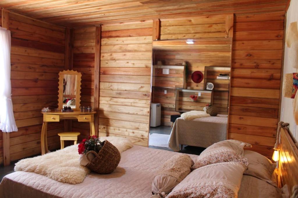 a bedroom with two beds in a room with wooden walls at Bangalô-Nosso Escritorio-Hospedagem Rural in Muniz Freire