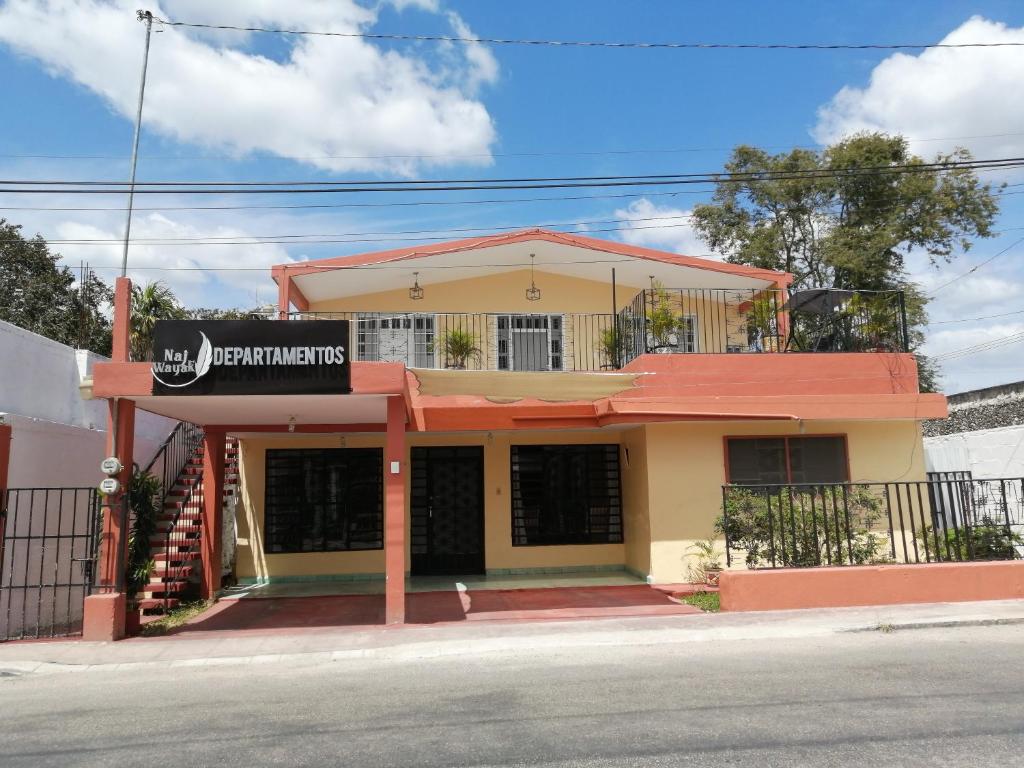 a building with a sign in front of it at Naj Wayak´ Departamentos in Valladolid