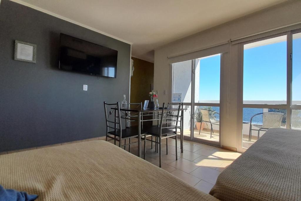 a bedroom with a table with chairs and a balcony at Amanecer Petit in Miramar