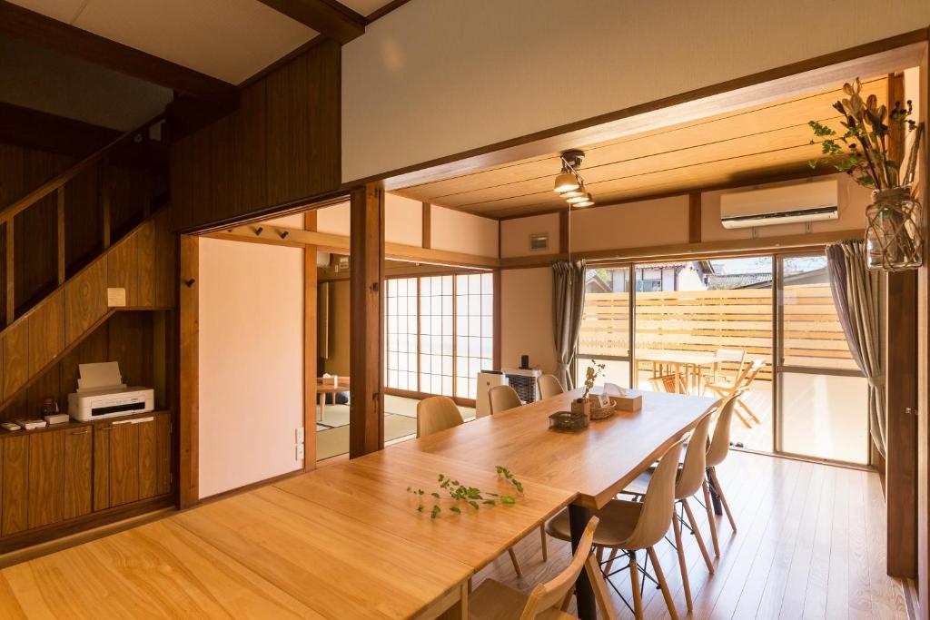 un comedor con una gran mesa de madera y sillas en tathata en Karuizawa