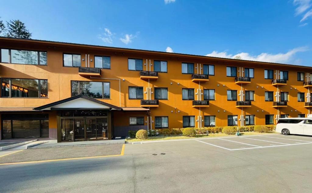 un bâtiment avec un parking en face de celui-ci dans l'établissement Fujinomori Hotel, à Fujikawaguchiko