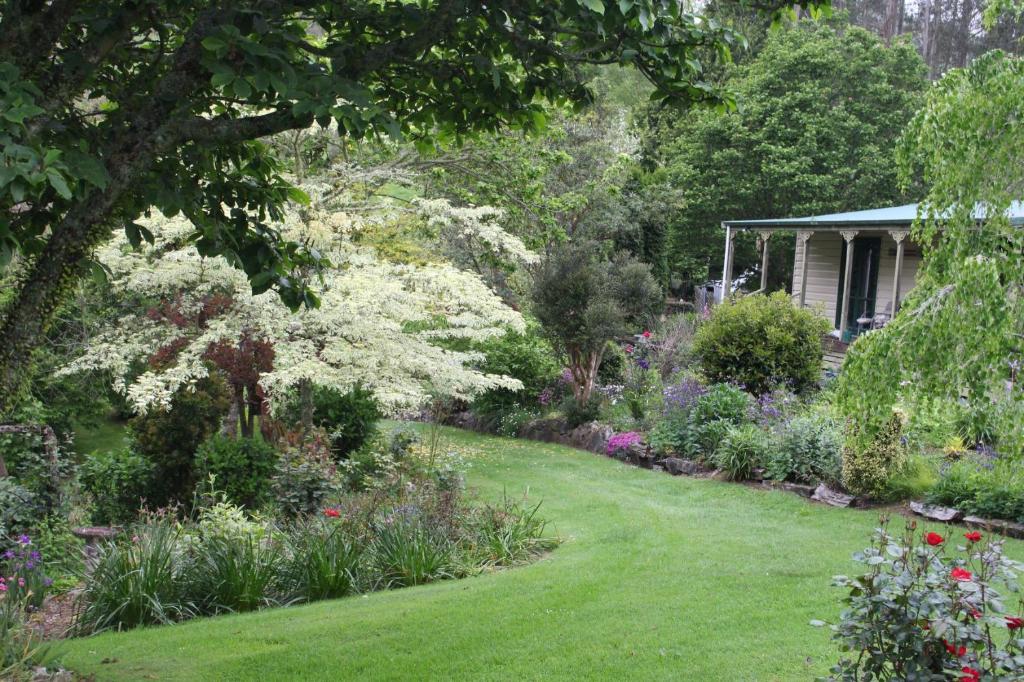 a garden with flowers and a house at Aramatai Gardens in Te Kuiti