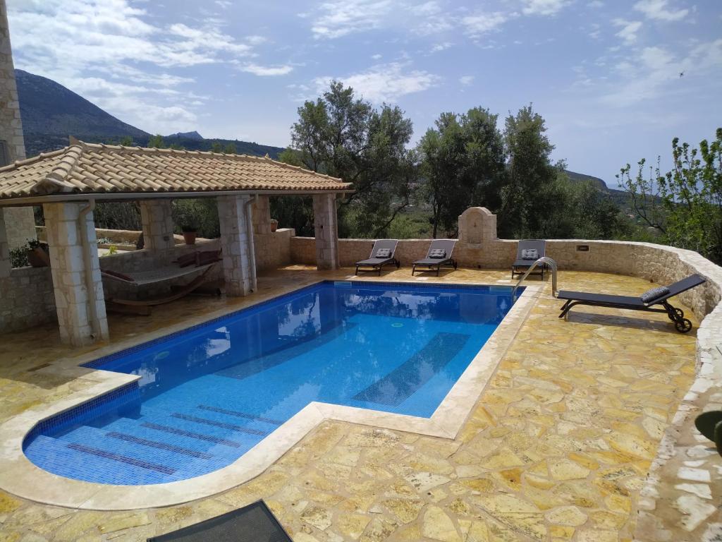 een zwembad met 2 stoelen en een prieel bij Villa Antares in Riglia