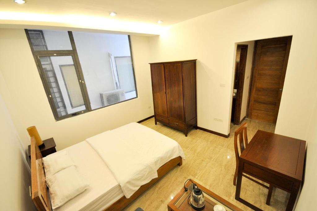 1 dormitorio con cama, mesa y espejo en Studio apartment Xom Chua, en Hanói