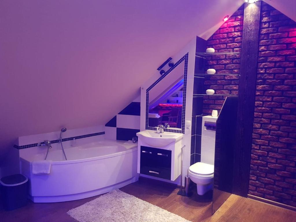 a bathroom with a tub and a sink and a toilet at Rodzinny ,Luksusowy Apartament nad jeziorem w centrum Mragowa in Mrągowo