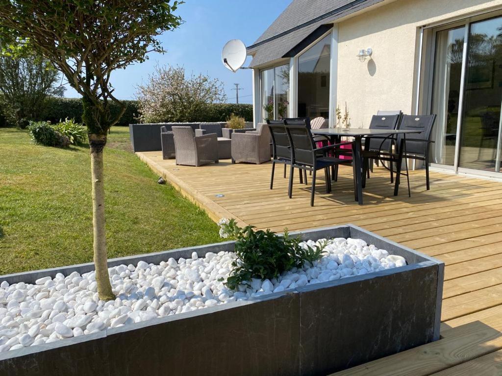 une terrasse en bois avec une table et des chaises. dans l'établissement Grande Greve Roscoff, à Roscoff