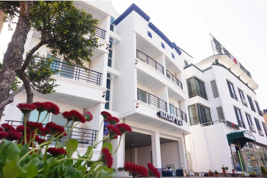 un bâtiment avec des fleurs rouges devant lui dans l'établissement Naksanstay, à Yangyang