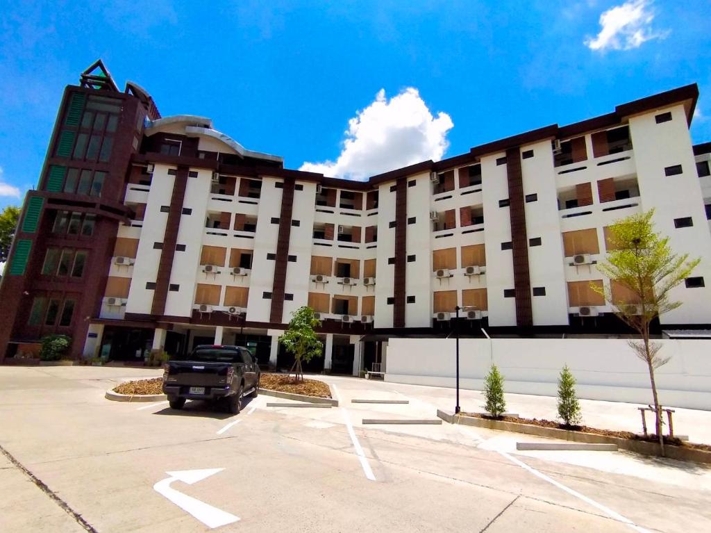 a parking lot in front of a building at Aileen Hotel in Khon Kaen