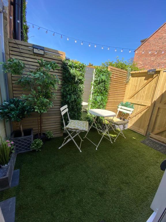 un patio trasero con una mesa y sillas y una valla en OurStudio en Beverley