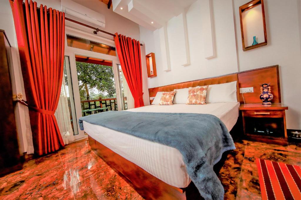 a bedroom with a bed with red curtains and a window at Y&Y Residence in Kandy
