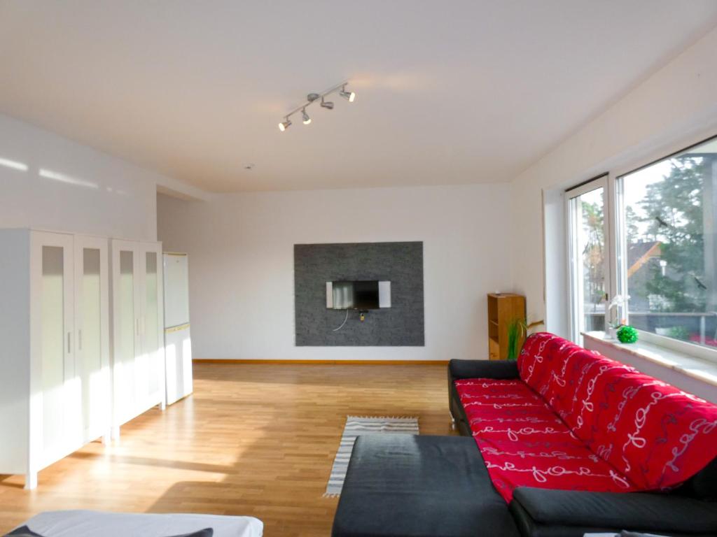 sala de estar con sofá rojo y TV en SUNNYHOME Monteurwohnungen und Apartments in Bodenwöhr en Bodenwöhr