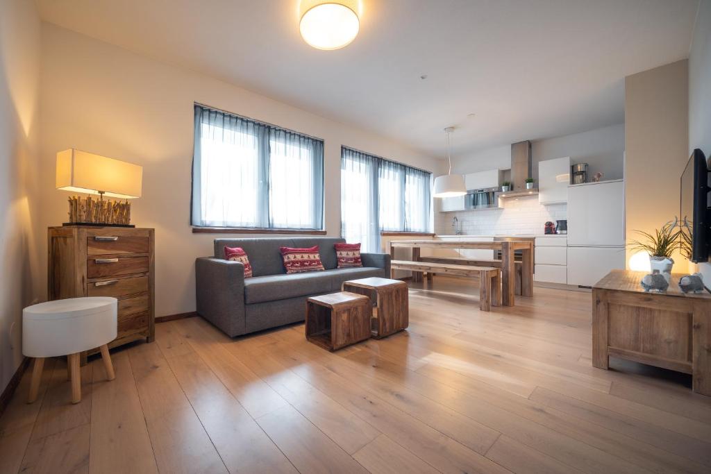 sala de estar amplia con sofá y cocina en Appartement AROSA by Schladming-Appartements, en Schladming