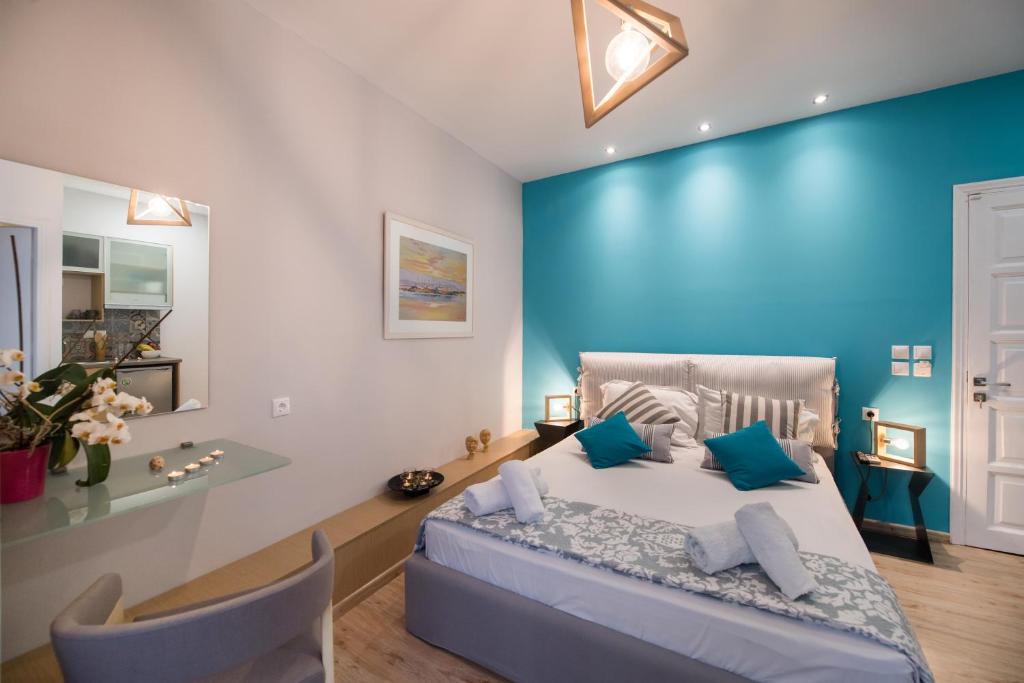 Un dormitorio con una pared azul y una cama con almohadas azules. en LEFKAS CITY APARTMENTS & Suites, en Lefkada