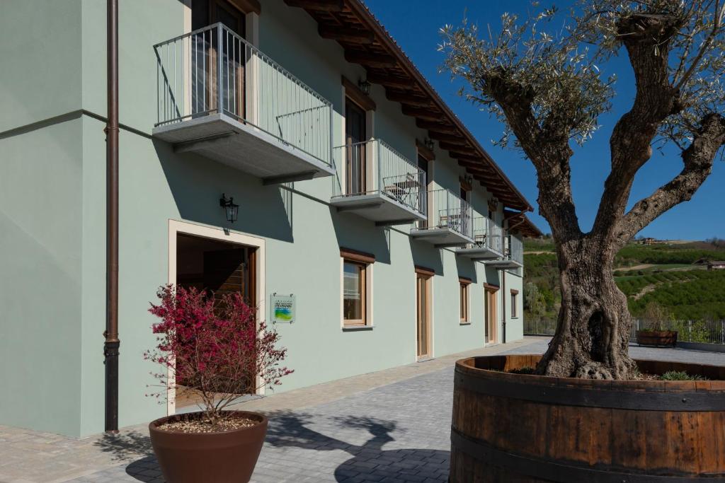 un bâtiment avec un arbre en face dans l'établissement Cascina Pajanòt, à Benevello