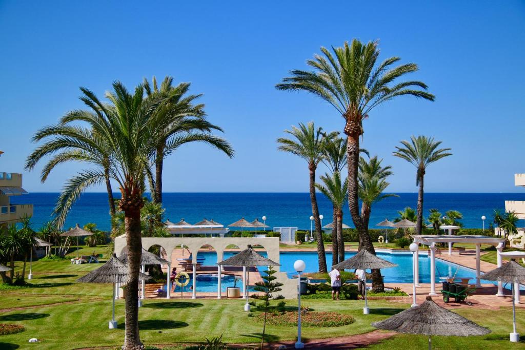 - Vistas a un complejo con palmeras y piscina en Playa Dorada, en Denia