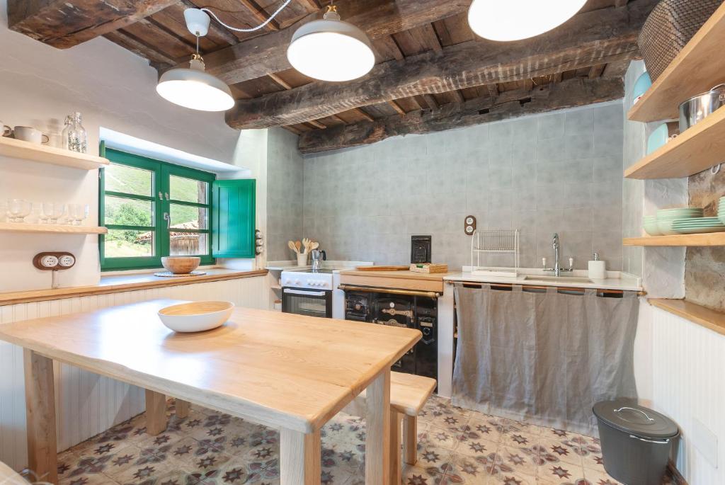 cocina con mesa de madera y fregadero en Terra Ecoturismo Casa La Casita verde, en La Focella
