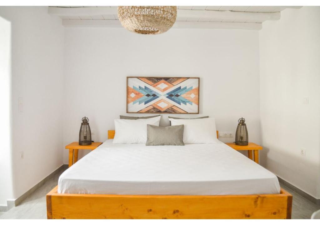 a bedroom with a large bed with white sheets at bougainvillea home at Plaka in Plaka Milou