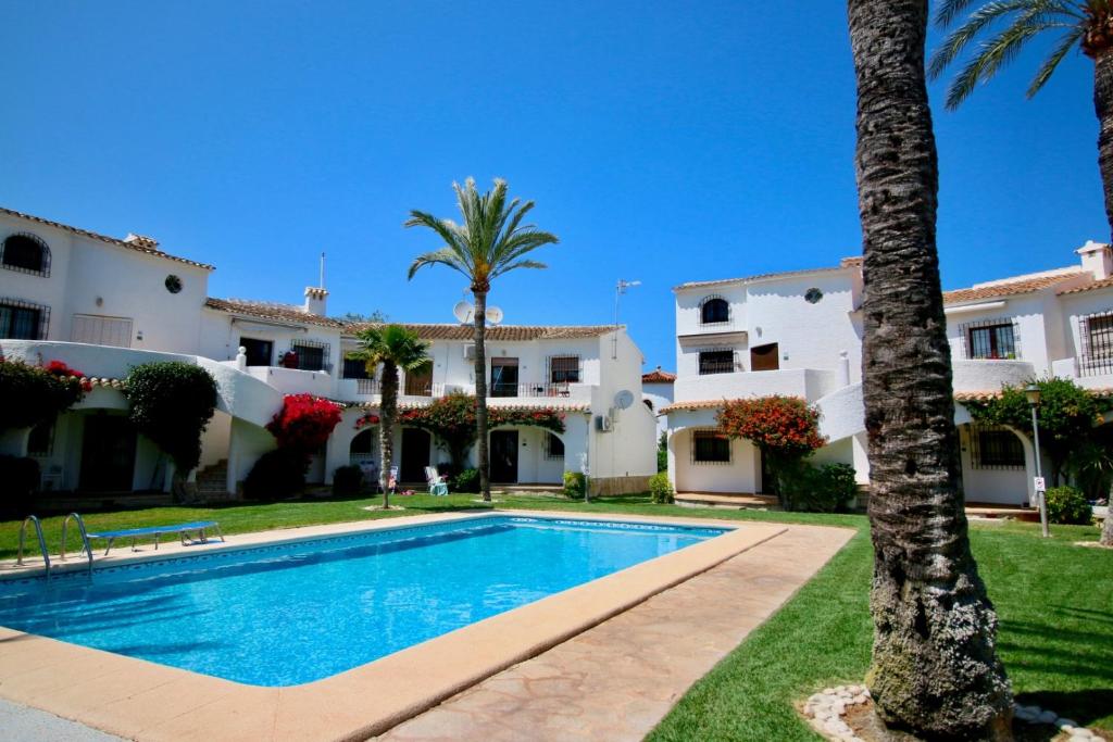 eine Villa mit einem Pool und Palmen in der Unterkunft Oasis Parc 45 in Denia