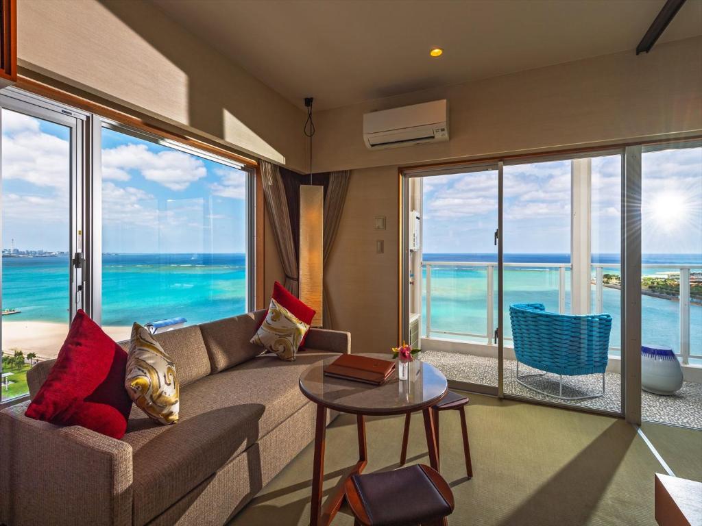 a living room with a couch and a view of the ocean at oile by DSH Resorts in Chatan