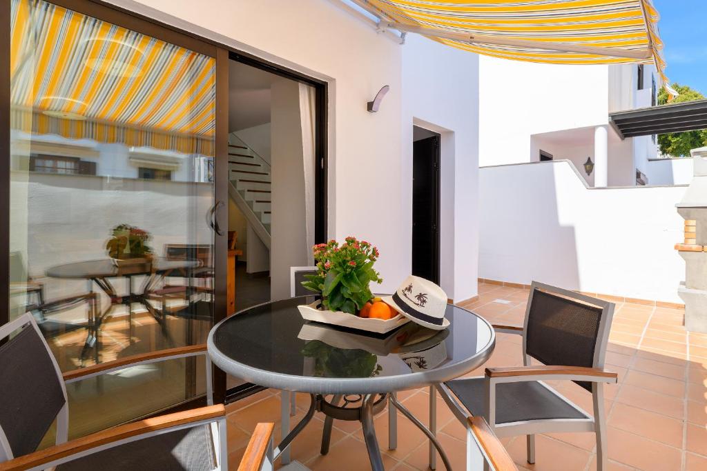 een eetkamer met een tafel en stoelen op een balkon bij Casa Grumete, moderno y actual in Playa Honda