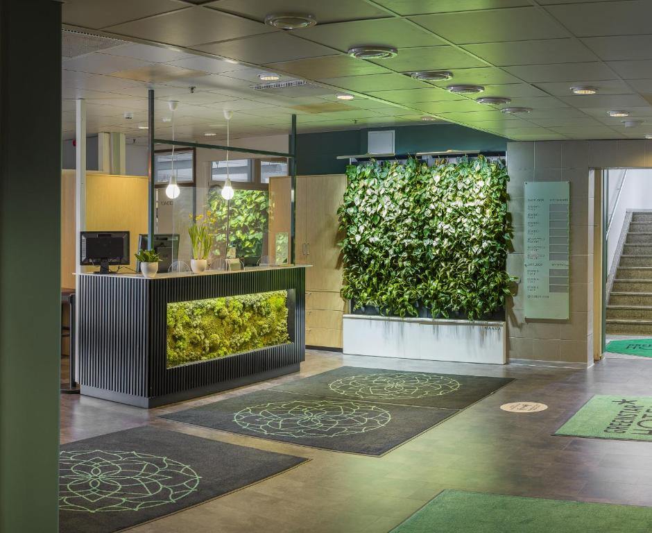 a lobby with a green wall with plants at GreenStar Hotel Lahti in Lahti