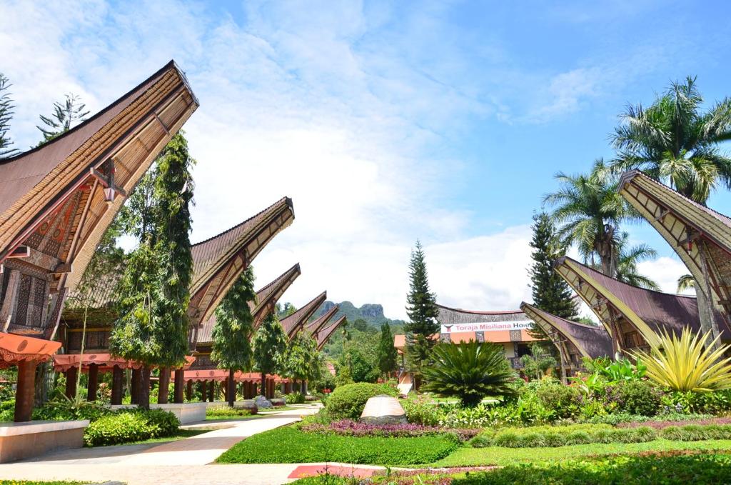 a resort with a garden and a building at Toraja Misiliana Hotel in Rantepao