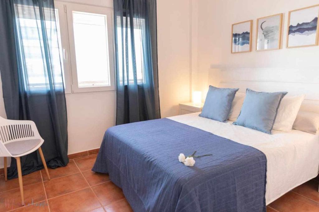 sypialnia z niebieskim łóżkiem z pluszakiem w obiekcie Apartamento nuevo junto a la playa , vistas al mar w mieście Punta Umbría