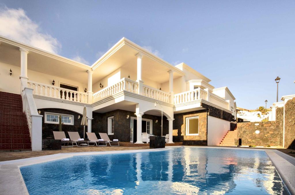 a house with a swimming pool in front of it at Villa Los Loros in Nazaret