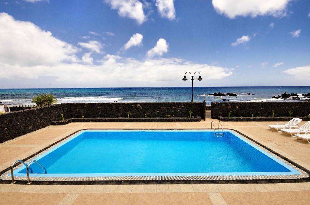 een zwembad met de oceaan op de achtergrond bij Villa Adelina in Punta de Mujeres