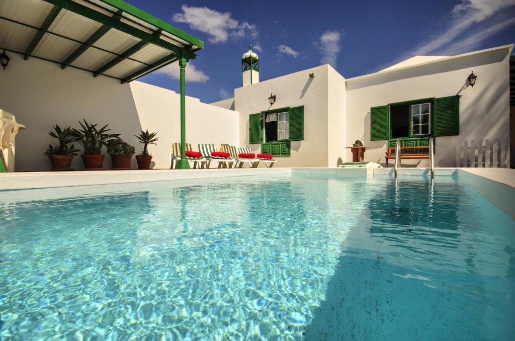 a swimming pool in front of a house at Casa Andrea in Mácher