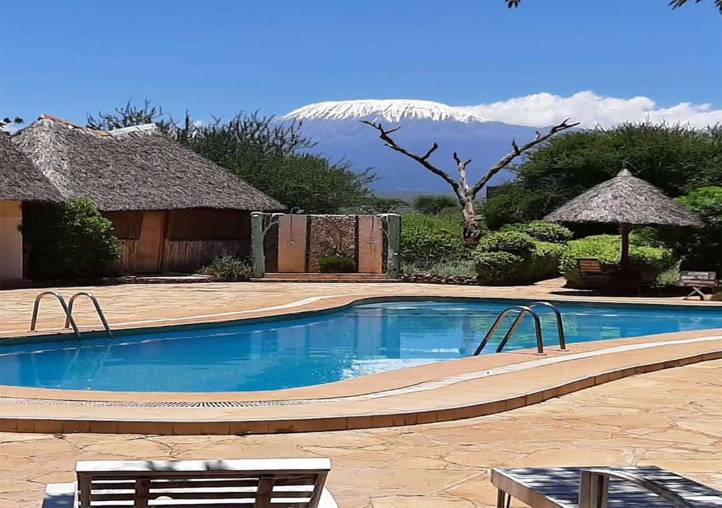 a swimming pool with a mountain in the background at AA Lodge Amboseli in Amboseli