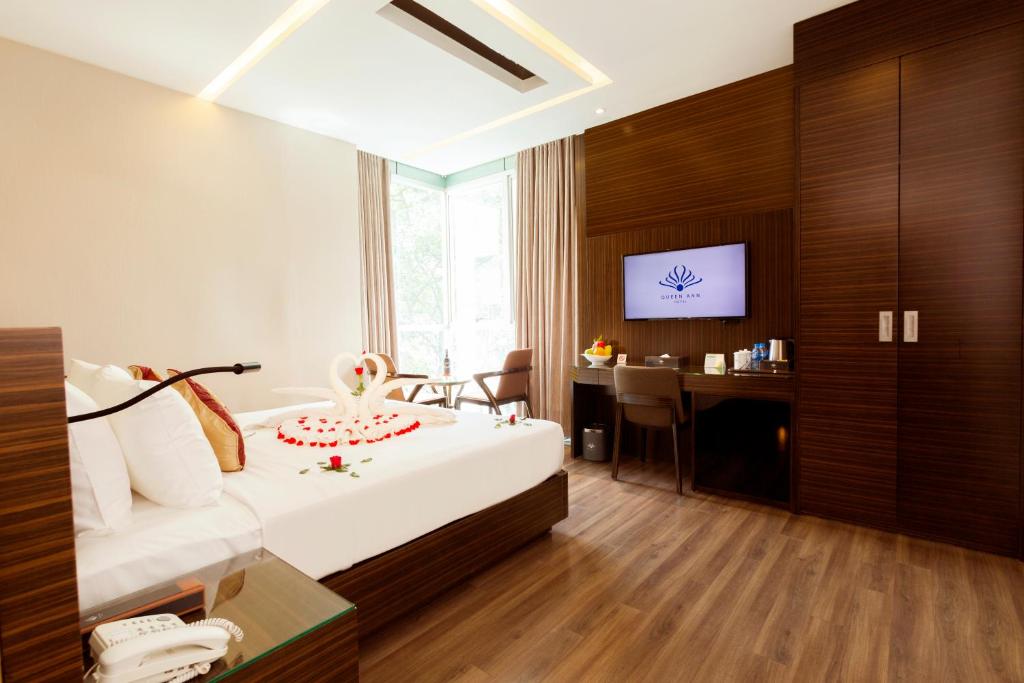 ein Hotelzimmer mit einem Bett und einem Schreibtisch in der Unterkunft Queen Ann Hotel in Ho-Chi-Minh-Stadt