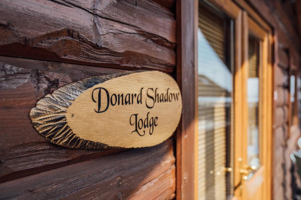 a wooden sign on the side of a building at Donard Shadow Lodge in Newcastle